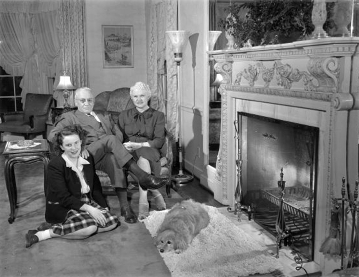 Oscar Rennebohm with wife Mary and daughter Carol Ann, seated in front of fireplace